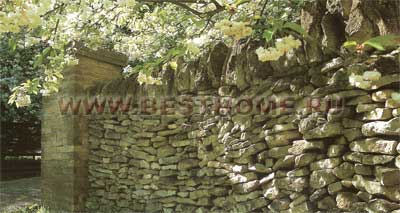 Сочетание сельского и классического стилей — неровная поверхность стены, сложенной на сухую из каменных плит прекрасно контрастирует с прямоугольным контрфорсом